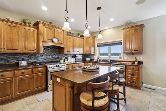 1259 Rose Dr, Niles, MI 49120 - kitchen with stainless steel gas stove, brown cabinetry, backsplash, a kitchen island, and recessed lighting