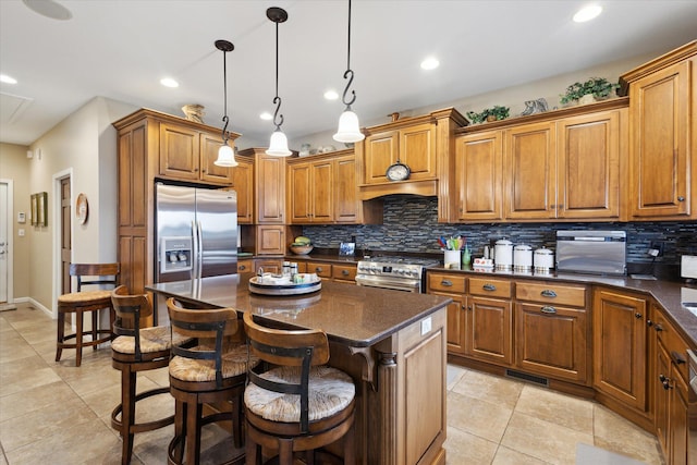 1259 Rose Dr, Niles, MI 49120 - kitchen with stainless steel appliances, brown cabinetry, backsplash, light tile patterned floors, and a breakfast bar