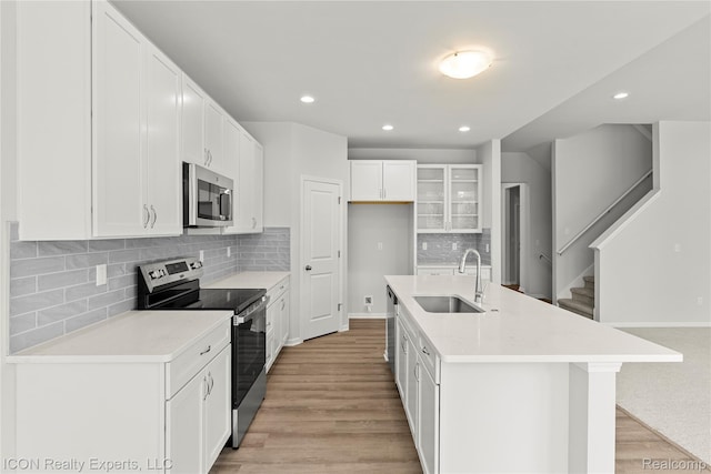 2396 Pondview Ln, Troy, MI 48085 - kitchen with appliances with stainless steel finishes, light wood finished floors, recessed lighting, backsplash, and white cabinets