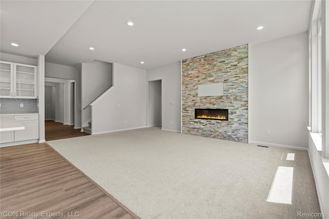 2396 Pondview Ln, Troy, MI 48085 - unfurnished living room featuring stairs, a fireplace, recessed lighting, and wood finished floors