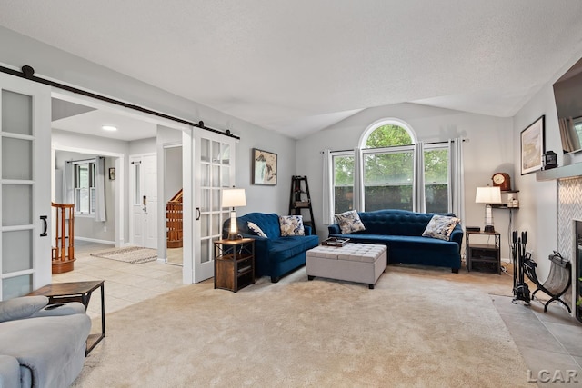 9705 Crescent Ct, Tecumseh, MI 49286 - living area with a barn door, light tile patterned flooring, lofted ceiling, and light colored carpet