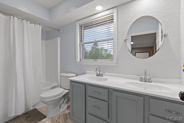 9705 Crescent Ct, Tecumseh, MI 49286 - bathroom with double vanity, shower / bath combo with shower curtain, and toilet