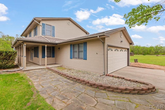 9705 Crescent Ct, Tecumseh, MI 49286 - back of house with an attached garage, concrete driveway, a lawn, and covered porch