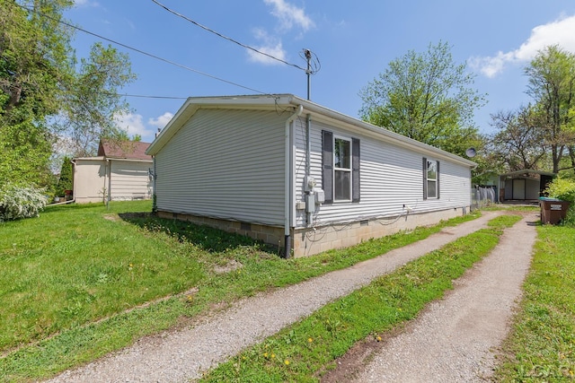 943 Howell Ave, Adrian, MI 49221 - view of side of home with a lawn, a storage shed, dirt driveway, an outbuilding, and crawl space