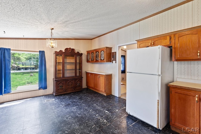 943 Howell Ave, Adrian, MI 49221 - kitchen with freestanding refrigerator, ornamental molding, brown cabinetry, a textured ceiling, and light countertops
