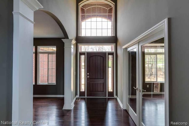 7118 Oak Ridge Ct, Clarkston, MI 48348 - entryway featuring ornate columns, hardwood / wood-style floors, arched walkways, and baseboards