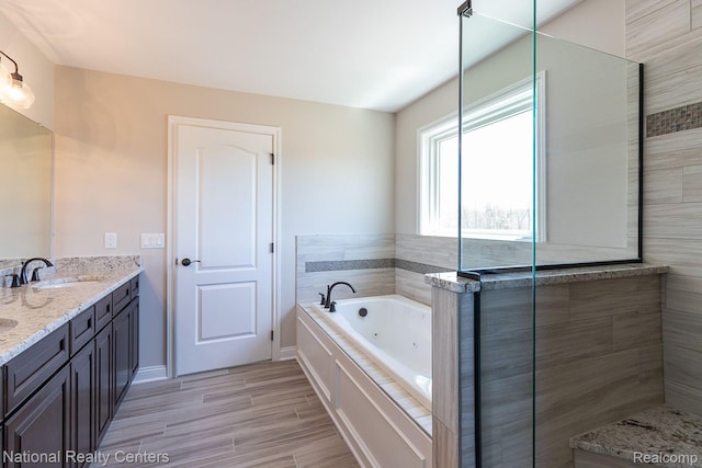 7118 Oak Ridge Ct, Clarkston, MI 48348 - bathroom featuring a whirlpool tub, double vanity, wood finished floors, and tiled shower