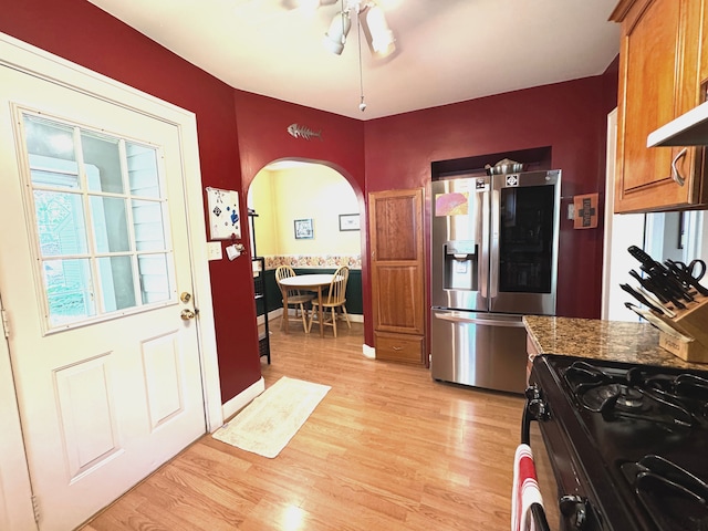 25220 Code Rd, Southfield, MI 48033 - kitchen with stainless steel fridge, gas stove, arched walkways, a ceiling fan, and light wood finished floors