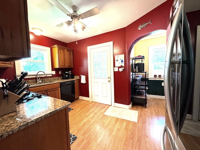 25220 Code Rd, Southfield, MI 48033 - kitchen featuring freestanding refrigerator, dishwasher, arched walkways, light wood-style floors, and a sink