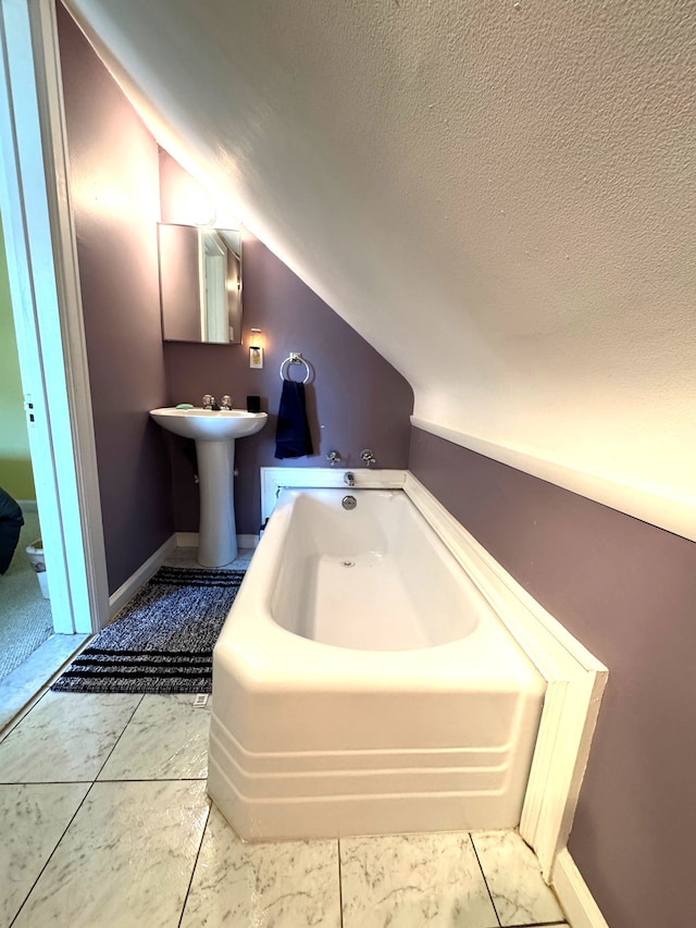 25220 Code Rd, Southfield, MI 48033 - full bathroom with a garden tub, vaulted ceiling, a textured ceiling, and a sink