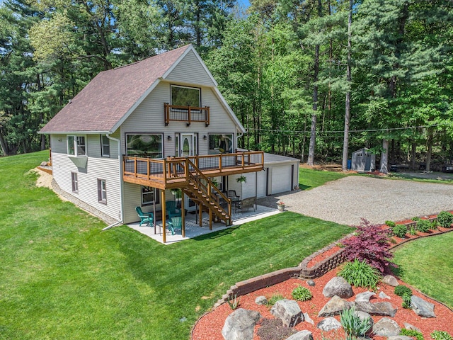 back of property with a patio area, a wooden deck, a storage unit, a shingled roof, and stairway