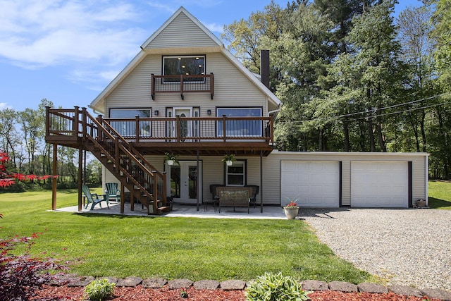 rear view of house with a deck, french doors, a yard, and driveway