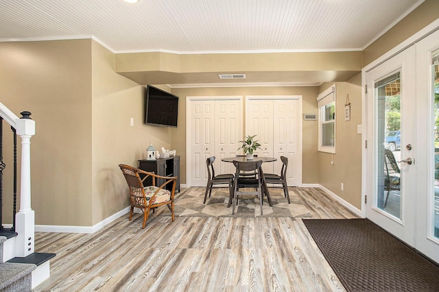dining area with light wood-style flooring, crown molding, and baseboards
