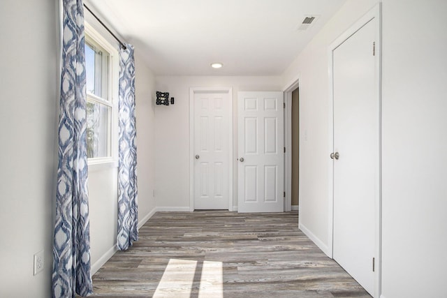 hallway with wood finished floors, baseboards, and recessed lighting