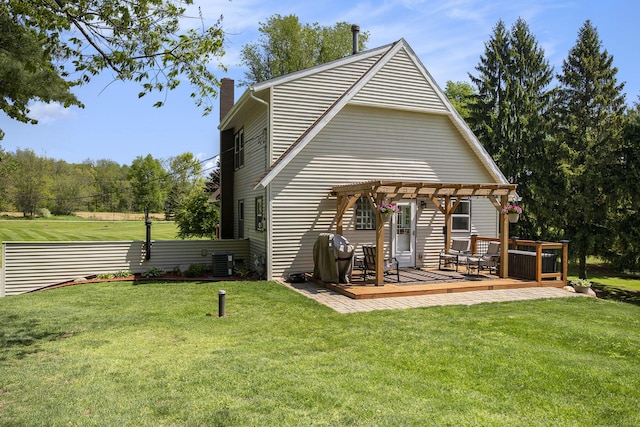 back of house with a pergola, a chimney, a wooden deck, central AC, and a lawn