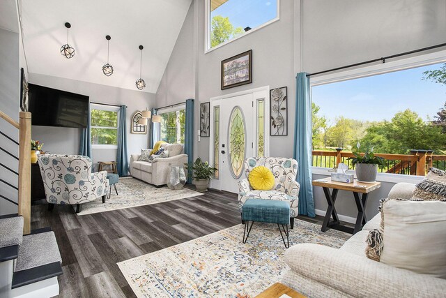 living room with high vaulted ceiling, wood finished floors, and stairway
