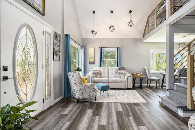 living room featuring stairway, plenty of natural light, high vaulted ceiling, and dark wood-style floors