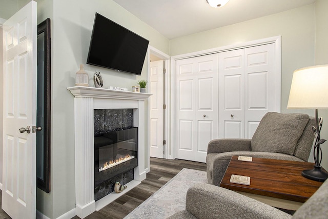 living area featuring dark wood finished floors, a fireplace, and baseboards