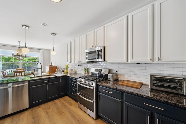 5639 Heathland Cir, Clarkston, MI 48346 - kitchen featuring appliances with stainless steel finishes, a sink, white cabinets, backsplash, and dark stone counters