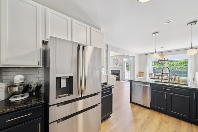5639 Heathland Cir, Clarkston, MI 48346 - kitchen with stainless steel appliances, a sink, tasteful backsplash, white cabinets, and dark stone countertops