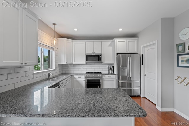 52851 Schafers Run Ct, Chesterfield, MI 48051 - kitchen featuring appliances with stainless steel finishes, a peninsula, white cabinets, backsplash, and recessed lighting