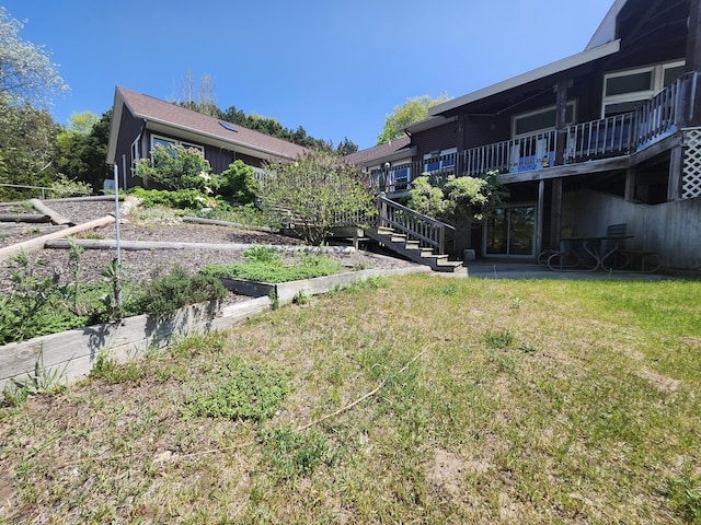 5005 S Brye Rd, Ludington, MI 49431 - view of grassy yard featuring a vegetable garden, stairway, and a wooden deck
