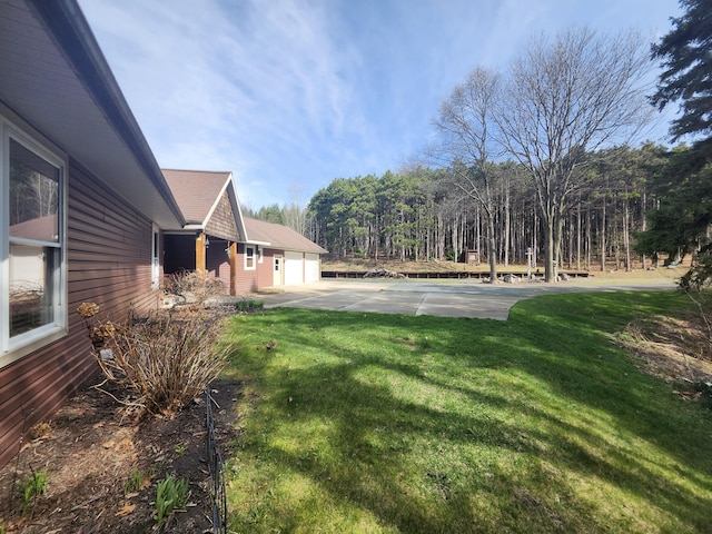 5005 S Brye Rd, Ludington, MI 49431 - view of green lawn featuring a garage and concrete driveway