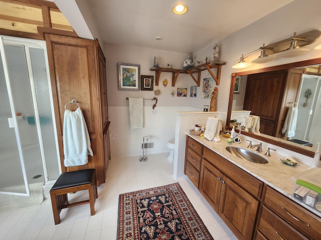5005 S Brye Rd, Ludington, MI 49431 - full bath featuring a shower stall, a wainscoted wall, vanity, toilet, and tile patterned flooring