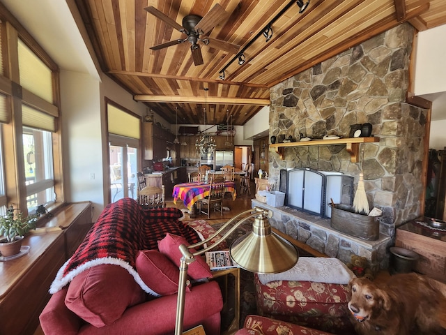 5005 S Brye Rd, Ludington, MI 49431 - living room featuring wood ceiling, beamed ceiling, ceiling fan, and a stone fireplace