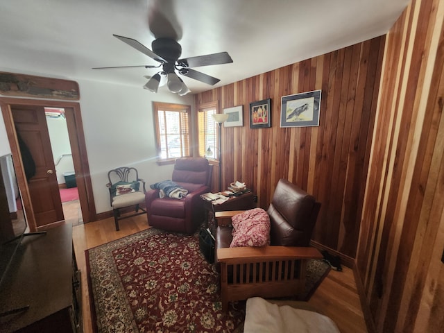 5005 S Brye Rd, Ludington, MI 49431 - living area with wood finished floors, a ceiling fan, wooden walls, and baseboards