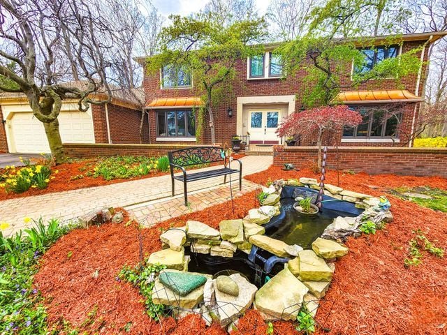 5130 Lake Bluff Rd, West Bloomfield, MI 48323 - view of front of house with brick siding and a garden pond