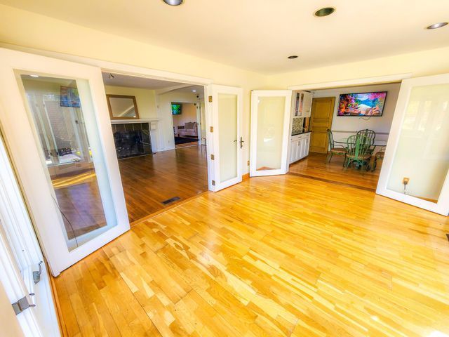 5130 Lake Bluff Rd, West Bloomfield, MI 48323 - unfurnished room with light wood-style flooring, a fireplace, french doors, and recessed lighting