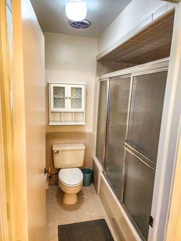 5130 Lake Bluff Rd, West Bloomfield, MI 48323 - full bath with toilet, enclosed tub / shower combo, tile walls, and tile patterned floors
