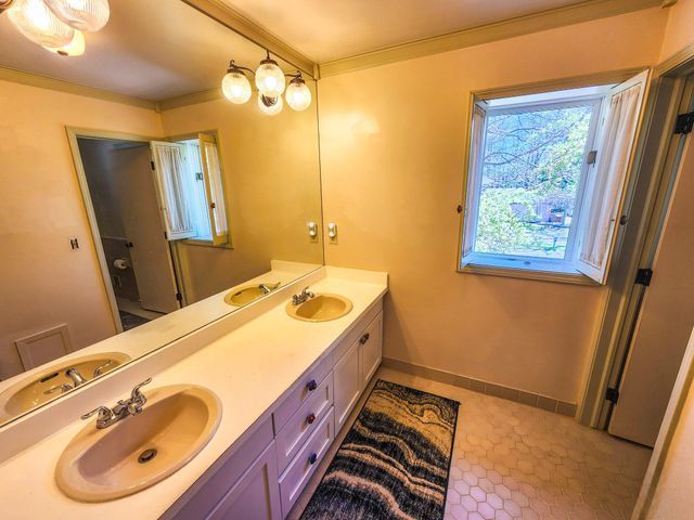 5130 Lake Bluff Rd, West Bloomfield, MI 48323 - full bath with double vanity, baseboards, and crown molding