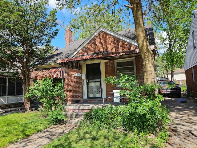 15770 Stansbury St, Detroit, MI 48227 - view of front facade with brick siding, a chimney, and a shingled roof