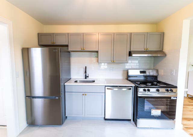 27396 Beechurst St, Roseville, MI 48066 - kitchen featuring appliances with stainless steel finishes, a sink, under cabinet range hood, and gray cabinetry