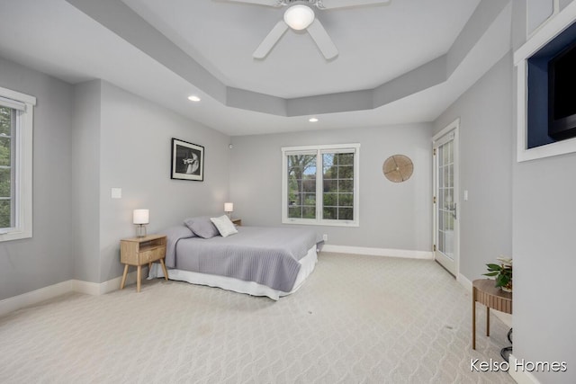 carpeted bedroom with recessed lighting, baseboards, multiple windows, a ceiling fan, and a raised ceiling