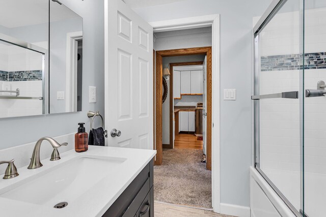 8595 Rives Junction Rd, Rives Junction, MI 49277 - bathroom featuring vanity, wood finished floors, and combined bath / shower with glass door
