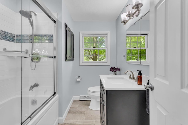 8595 Rives Junction Rd, Rives Junction, MI 49277 - bathroom featuring baseboards, vanity, toilet, shower / bath combination with glass door, and stone finish floors