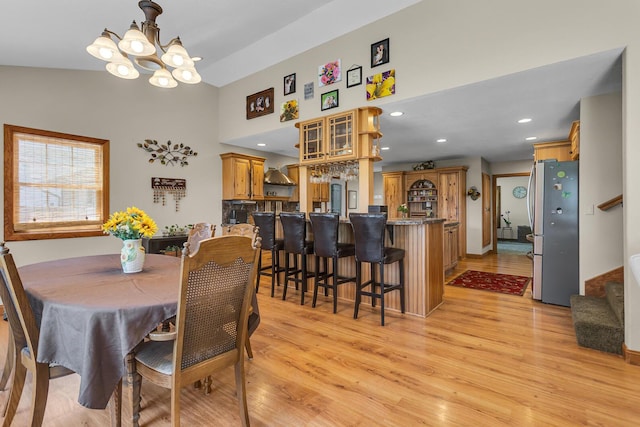 8595 Rives Junction Rd, Rives Junction, MI 49277 - dining space with light wood-style flooring, a chandelier, stairway, recessed lighting, and a towering ceiling