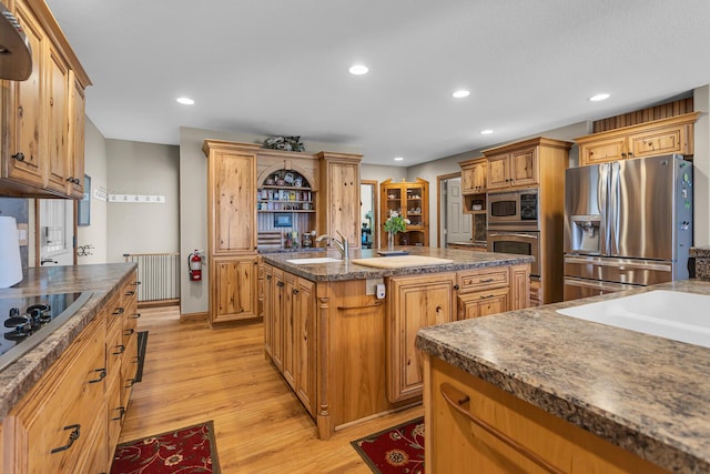 8595 Rives Junction Rd, Rives Junction, MI 49277 - kitchen with appliances with stainless steel finishes, a center island with sink, light wood-type flooring, recessed lighting, and dark countertops