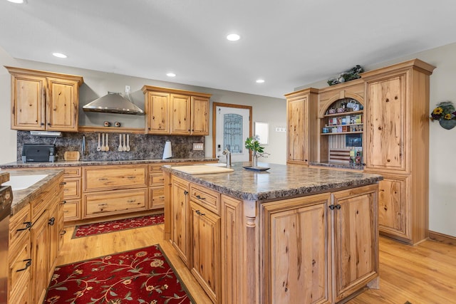 8595 Rives Junction Rd, Rives Junction, MI 49277 - kitchen with open shelves, light wood-style floors, decorative backsplash, a center island, and dark countertops