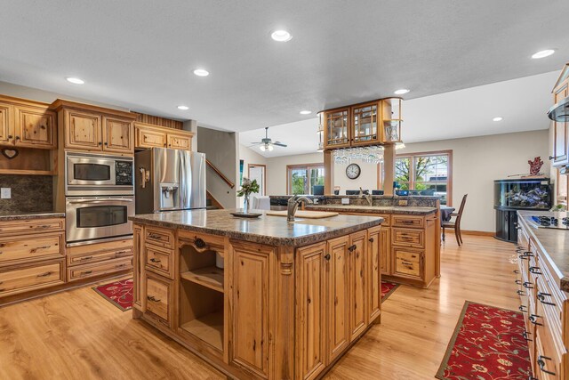 8595 Rives Junction Rd, Rives Junction, MI 49277 - kitchen with stainless steel appliances, open shelves, a kitchen island with sink, recessed lighting, and light wood-style flooring
