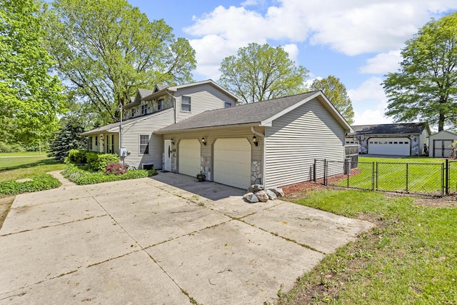 8595 Rives Junction Rd, Rives Junction, MI 49277 - view of home's exterior featuring an attached garage, concrete driveway, stone siding, and a gate