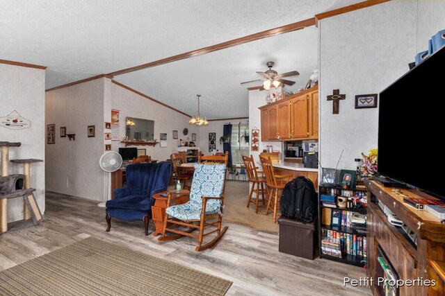 1633 Lavender Dr, Hastings, MI 49058 - living area featuring crown molding, light wood-style floors, a textured ceiling, vaulted ceiling, and ceiling fan