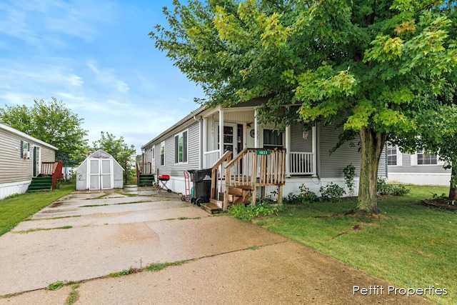1633 Lavender Dr, Hastings, MI 49058 - manufactured / mobile home featuring a storage unit, concrete driveway, an outbuilding, and a front lawn