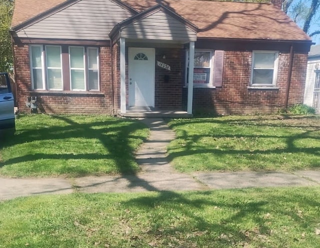 view of front of property featuring brick siding and a front lawn