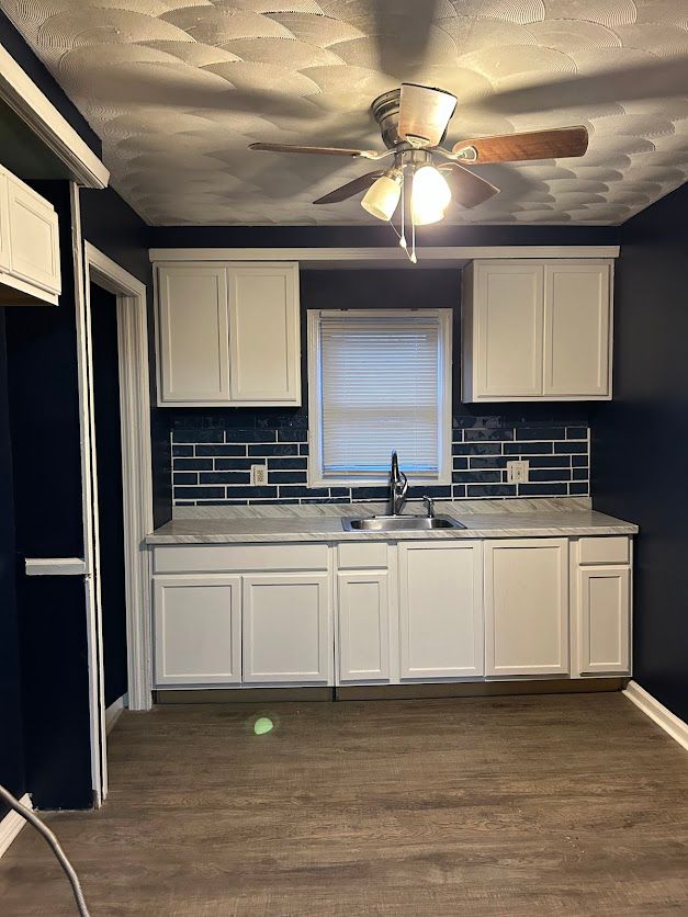 kitchen with a sink, tasteful backsplash, and white cabinets