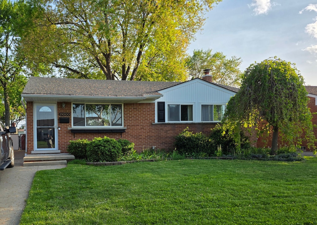 view of front of home with brick siding and a front lawn