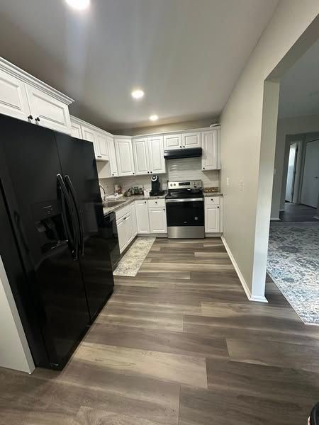 7350 N Inkster Rd Unit 10, Dearborn Heights, MI 48127 - kitchen with black appliances, under cabinet range hood, white cabinetry, a sink, and recessed lighting